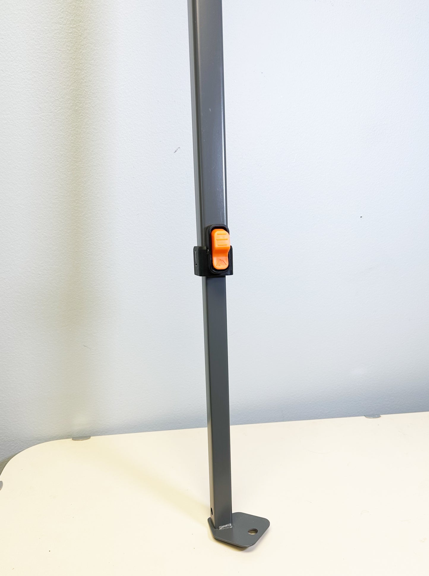 This image shows the lower section of an Ozark Trail canopy adjustable leg, highlighting the locking mechanism which is typically used to secure the leg at the desired height, and the foot of the leg that would rest on the ground to provide support for the canopy.