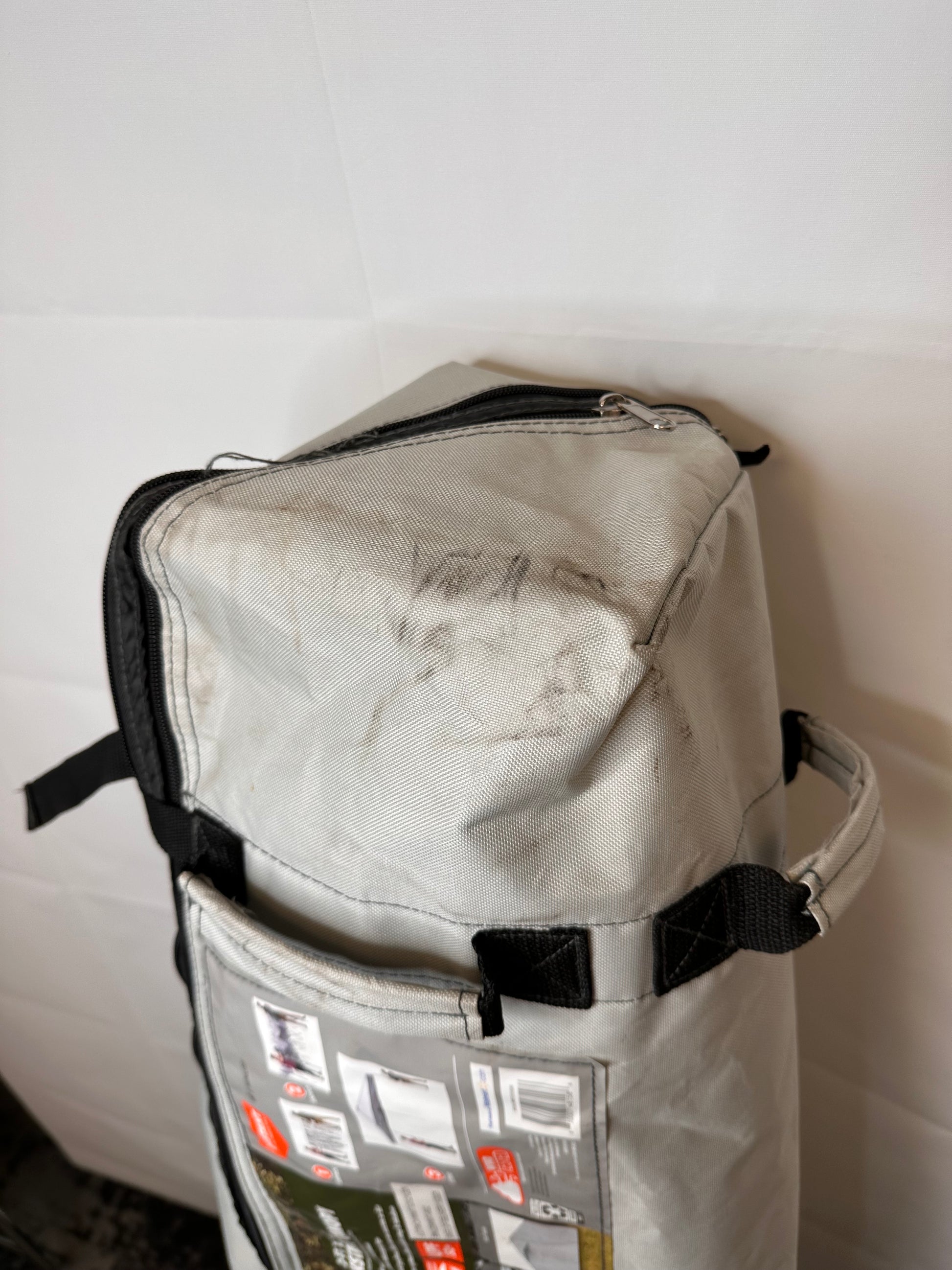 Wheeled carry bag for 12' x 12' Ozark Trail straight leg canopy frame, gray fabric bag with black straps and visible dirt marks from storage and handling