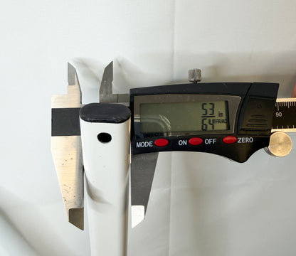 Digital caliper measuring the narrow-side thickness of the white canopy truss bar.