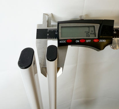 Digital caliper measuring the wide-side dimension of the white canopy truss bars.