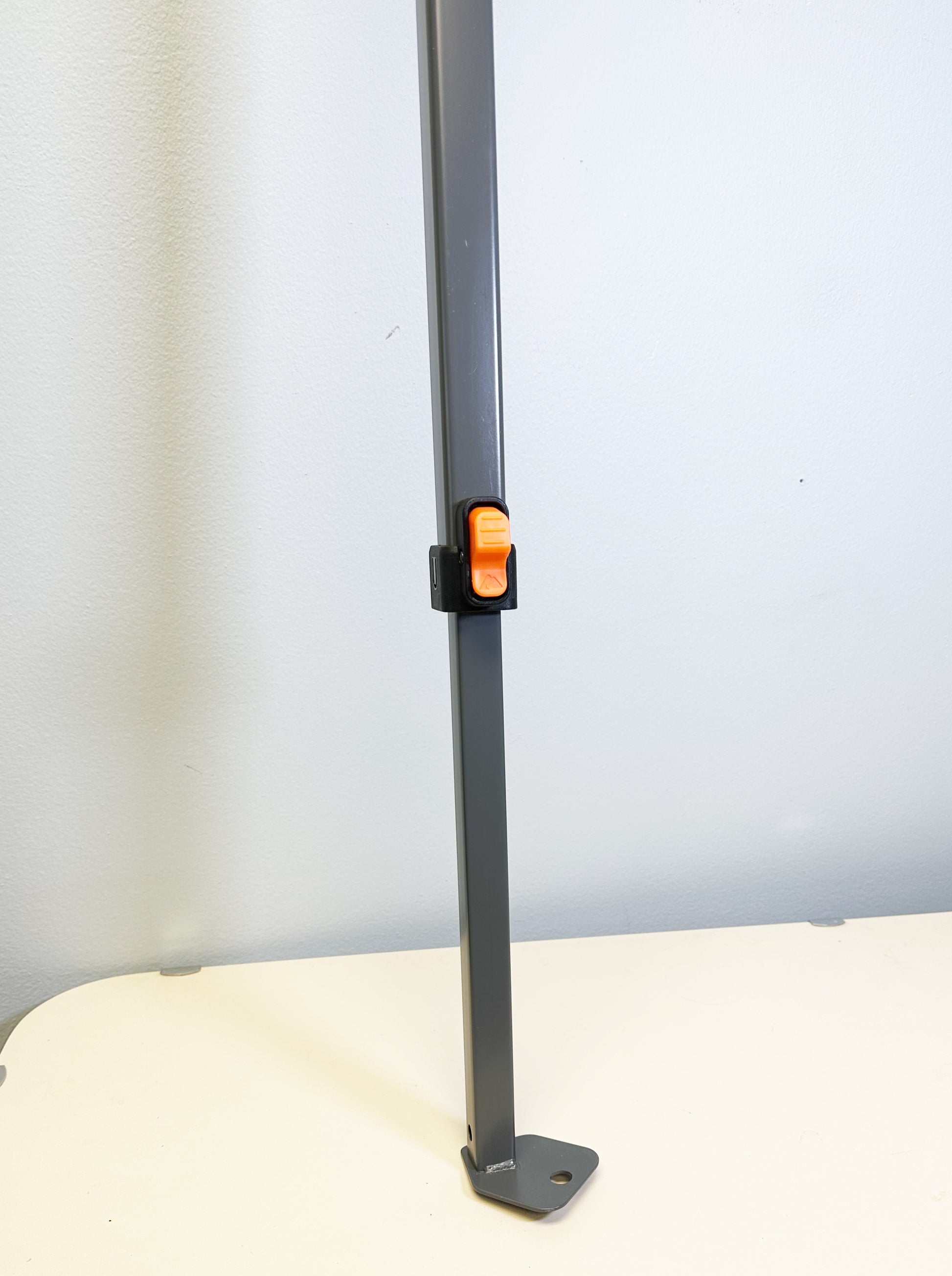  This image shows the lower section of an Ozark Trail canopy adjustable leg, highlighting the locking mechanism which is typically used to secure the leg at the desired height, and the foot of the leg that would rest on the ground to provide support for the canopy.