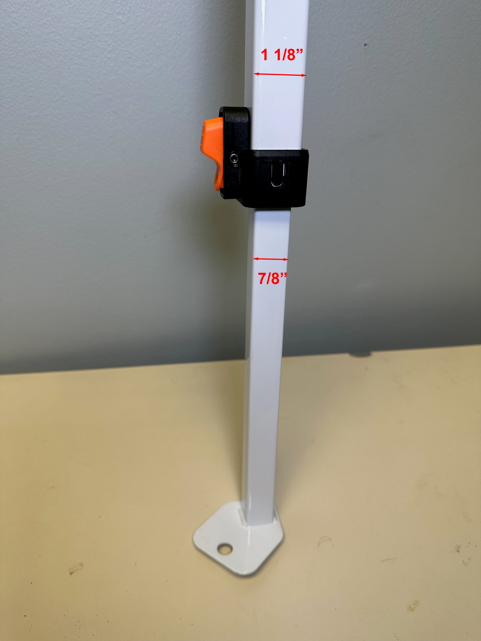 Vertical view of a white canopy leg with a black and orange leg slider attached, indicating measurements of 1 1/8" and 7/8" for different sections of the leg, likely for compatibility with an Ozark Trail canopy structure