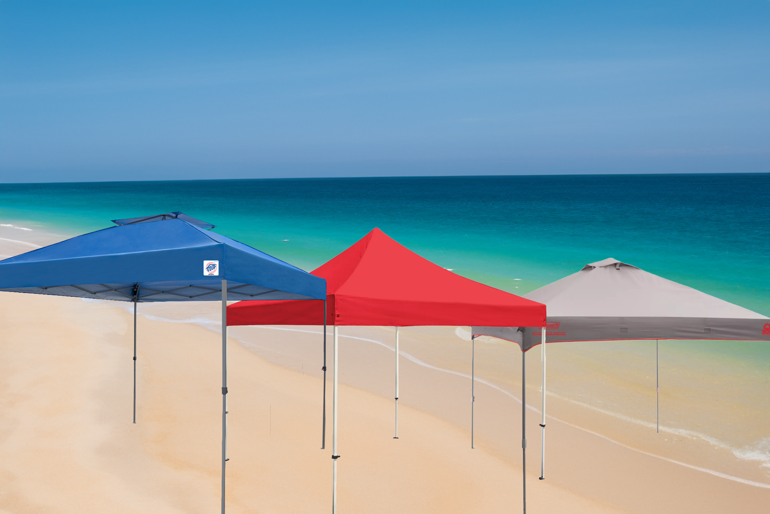 Three canopies on the sandy shore of the sea with a turquoise ocean in the background. The canopies are colored blue, red, and gray, set against a backdrop of a blue sky.